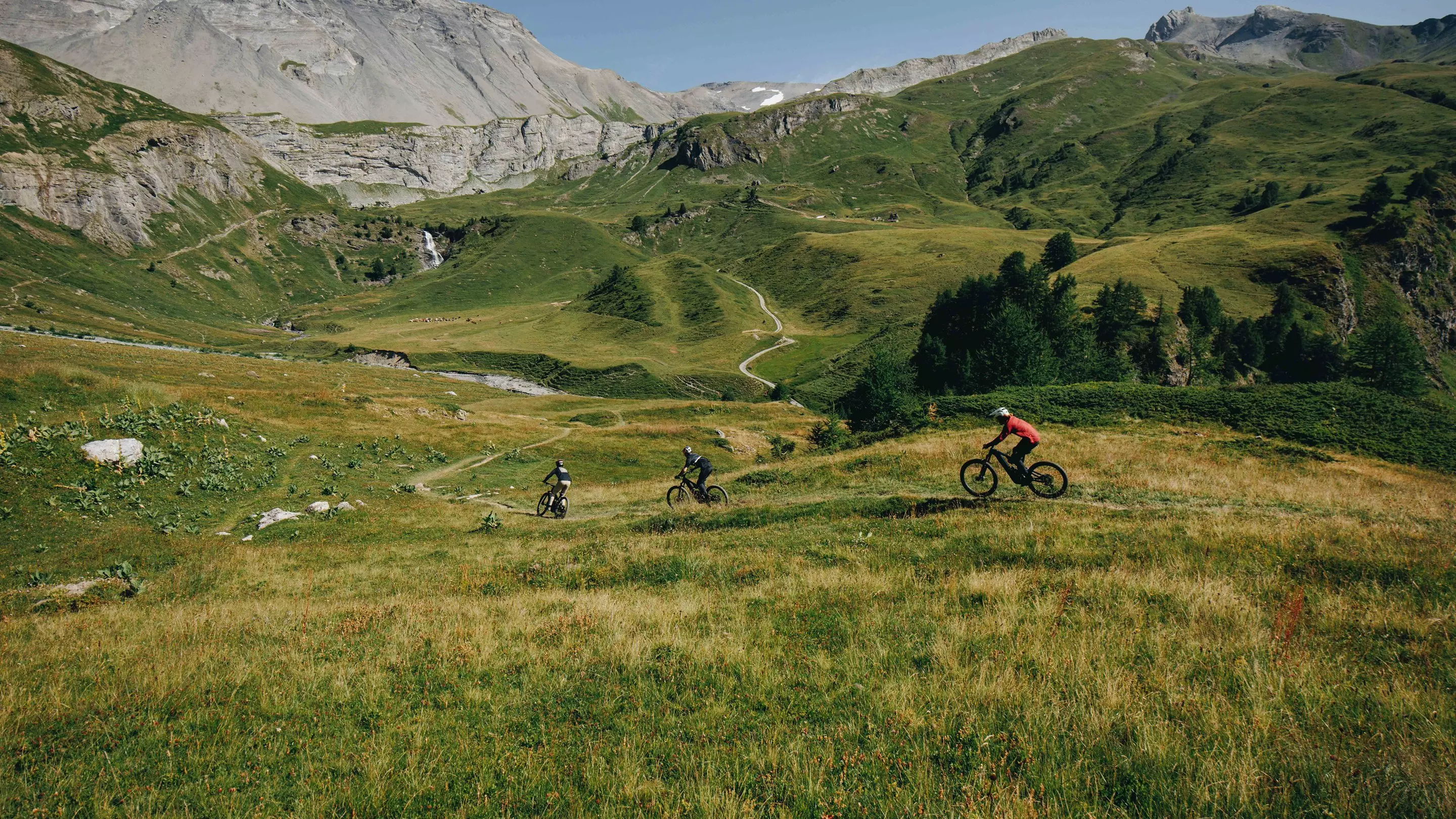 Tři horští cyklisté na trailové trati v Alpách